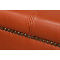 Close-up of stitching and nailhead trim on ottoman.