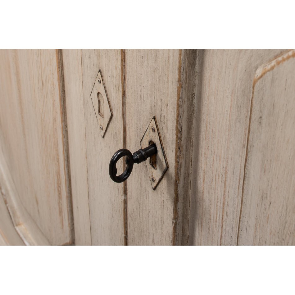 Detail of keyhole and key on credenza door.