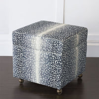 Closed storage ottoman cube on wooden floor.