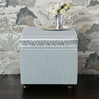 Sky blue ottoman cube with flowers atop in decor.