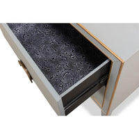 Open drawer of gray nightstand with patterned interior.