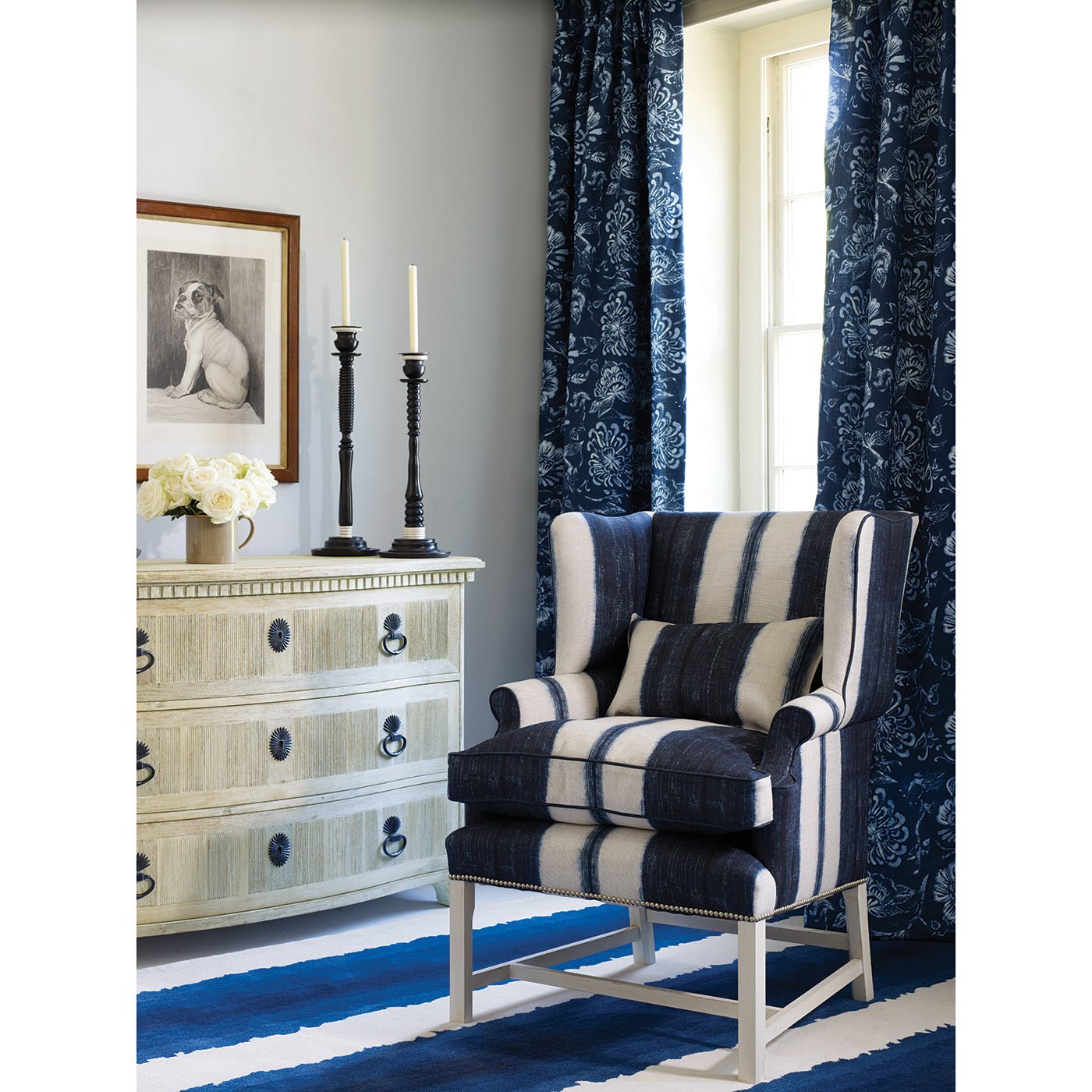 Dresser beside striped chair, in a decorated room.