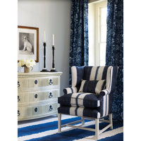 Dresser beside striped chair, in a decorated room.