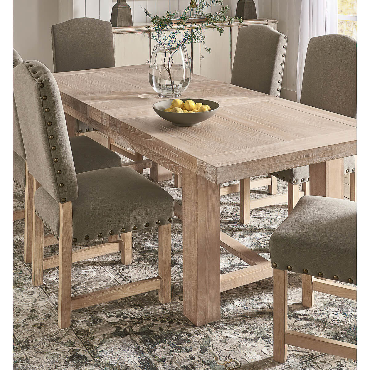 Dining table in room, decorated with chairs and vase.