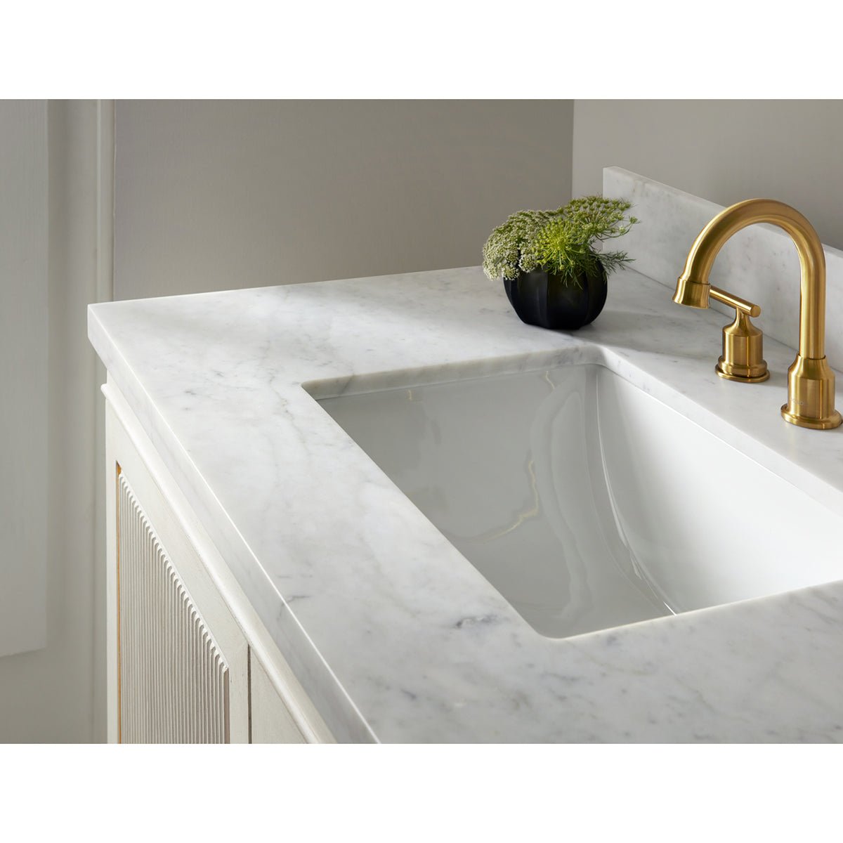 Close-up of marble sink and gold faucet.