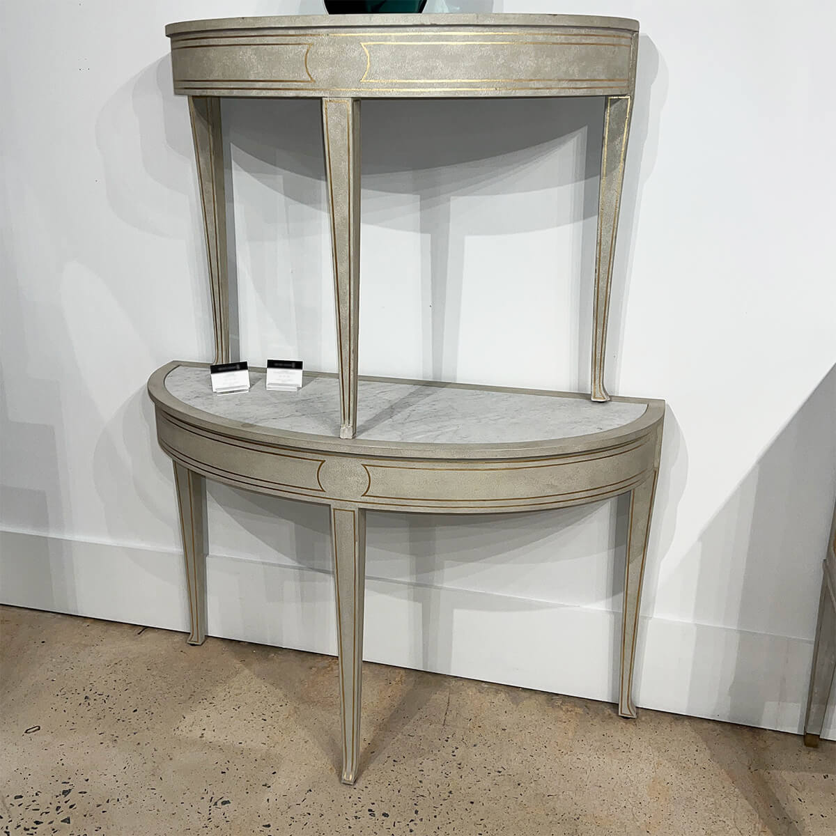 Stacked Swedish console tables against white wall display.