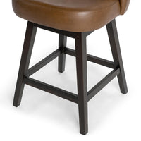 Close-up of the dark parawood base and footrest beneath the brown leather seat