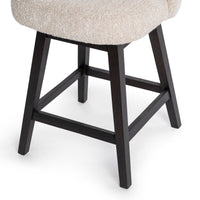 Close-up of the dark parawood legs and footrest beneath the cream upholstered seat