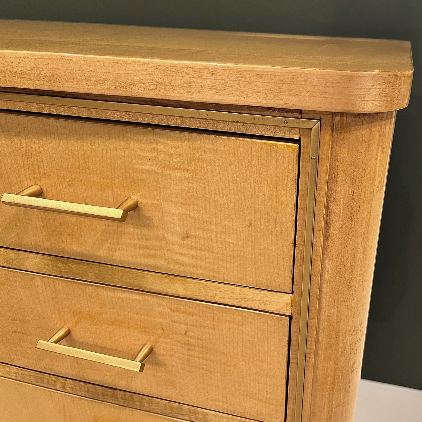 Close-up of brass handles on sycamore chest.