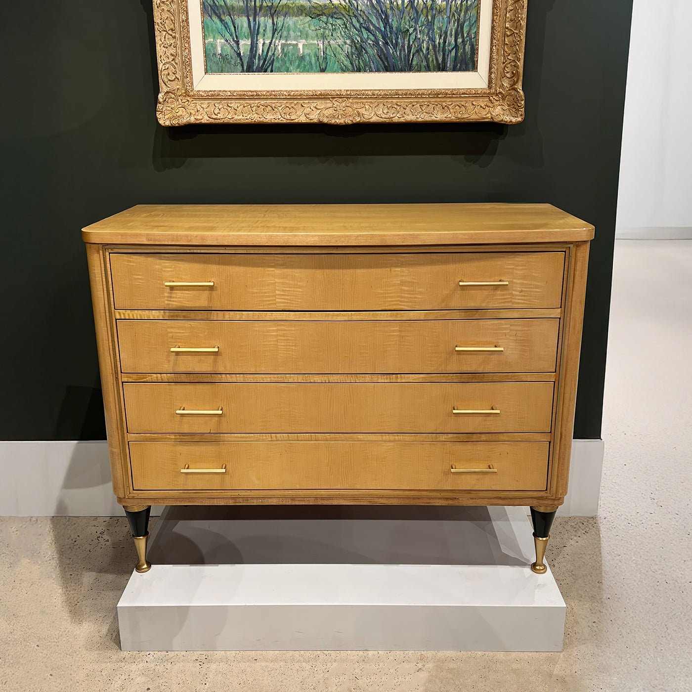 Chest on display with framed art above.