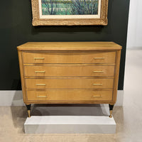 Chest on display with framed art above.
