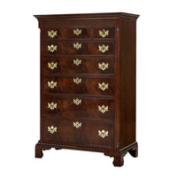 Tall Chippendale chest with ornate gold handles.