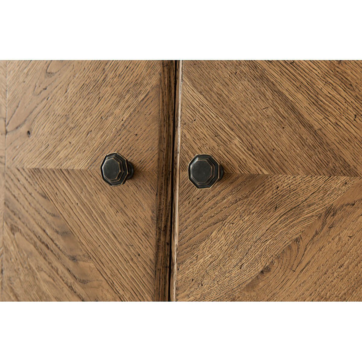 Close-up of cabinet door handles on light oak cabinet.