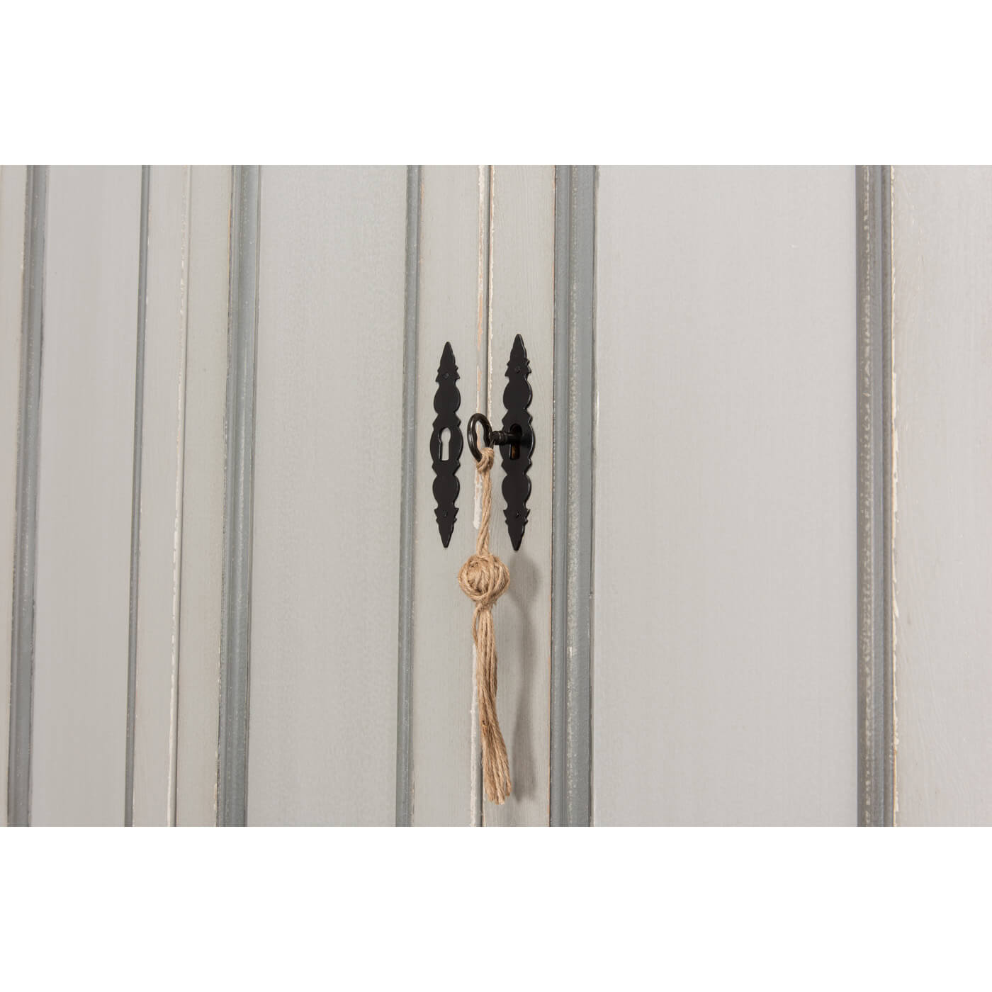 Close-up of cabinet door lock with tassel.