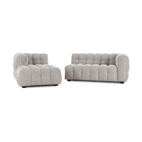Gray sectional shown as two separate chaise and sofa components with rounded, channeled upholstery