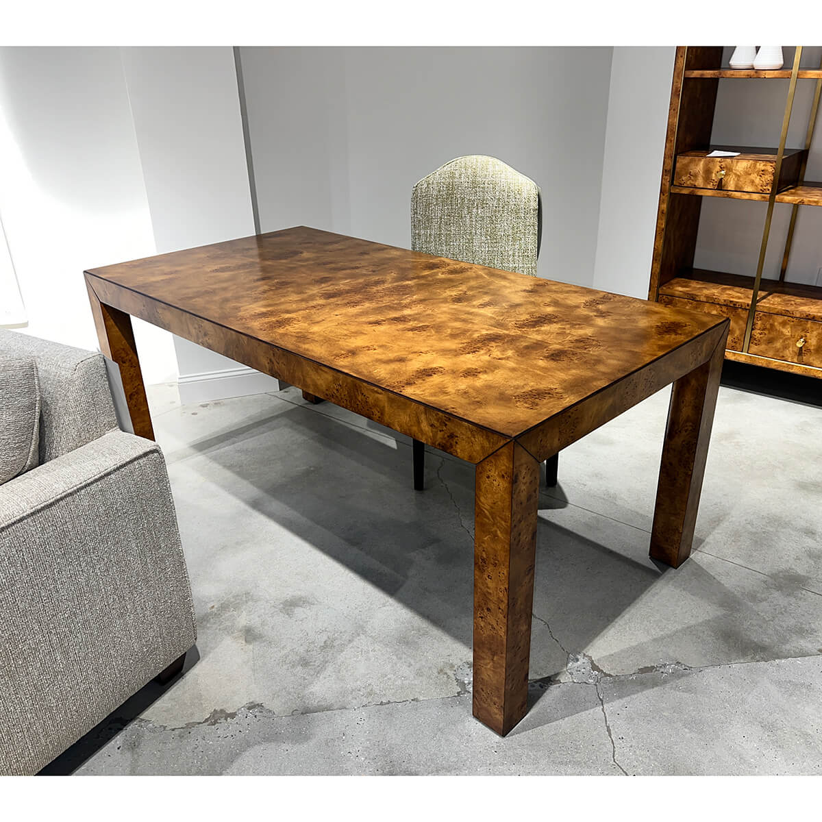 Burl wood desk in modern office, carpeted floor.