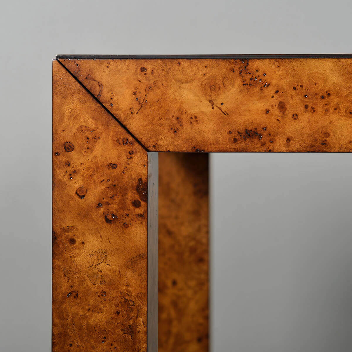 Close-up of burl wood desk corner detail.