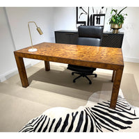 Burl wood desk in modern home office setting.