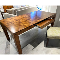 Open drawer of burl wood desk in office.