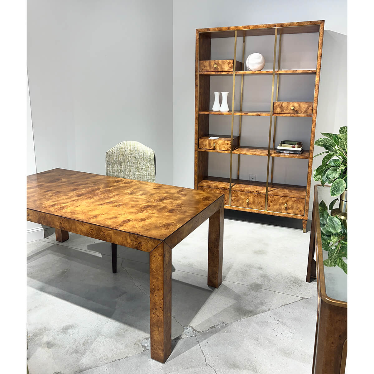 Burl wood desk in furnished office with shelving.