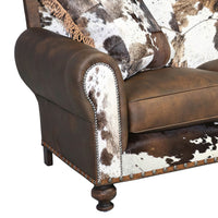 Close-up of sofa arm, brown leather, cowhide detail.