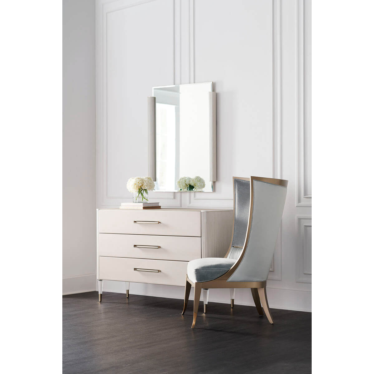 Three-drawer dresser with elegant chair and mirror.