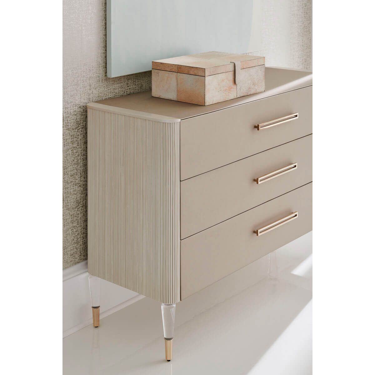 Three-drawer dresser in room corner with decorative box.