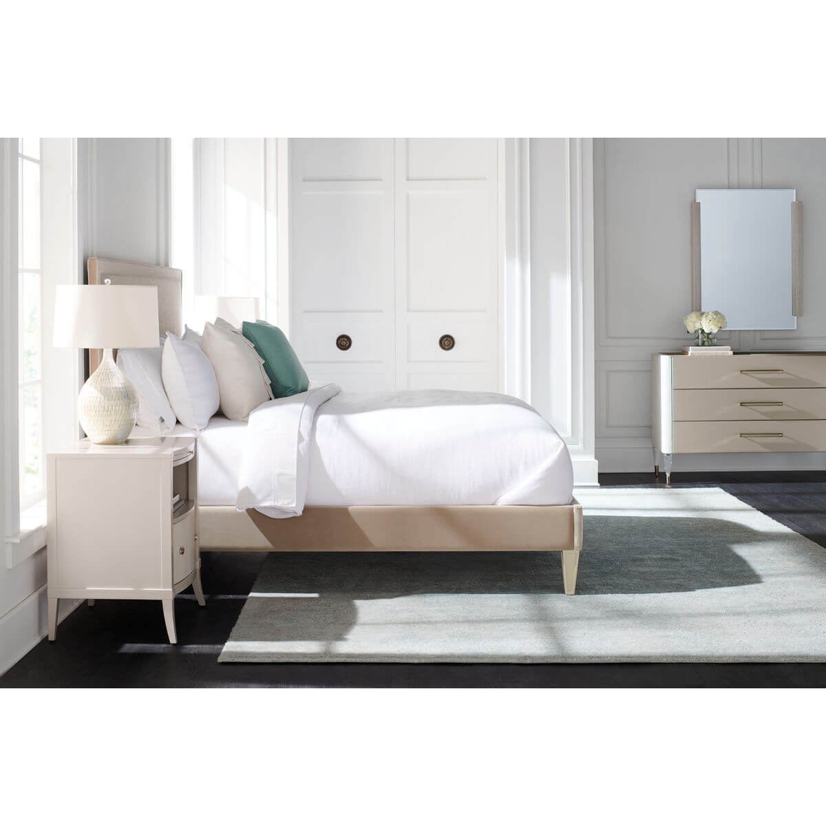 Bedroom with three-drawer dresser and bed, neutral tones.