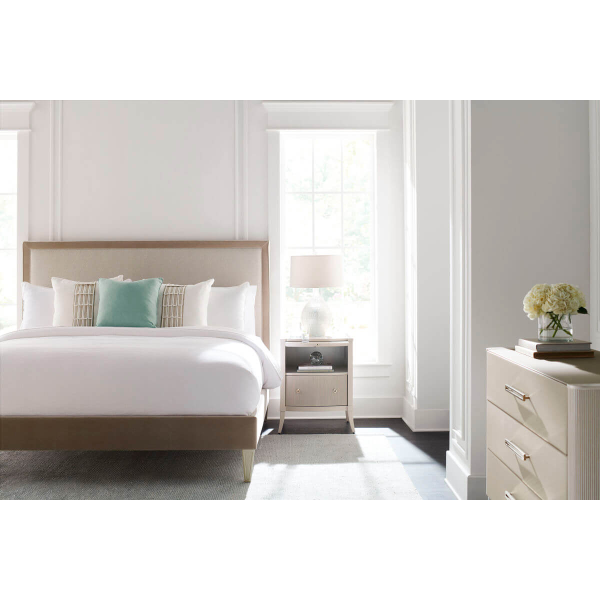 Bedroom setting with sunlight on three-drawer modern dresser.