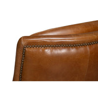 Nailhead trim detail on brown leather swivel chair