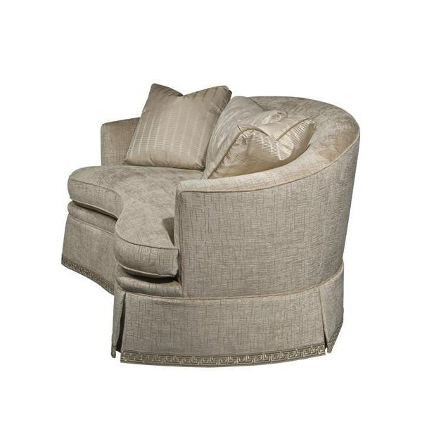 Side view of curved back sofa with pillows.