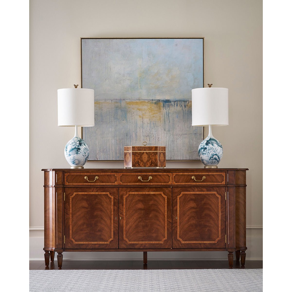 Traditional English sideboard styled with lamps and art.