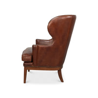 Brown leather wing chair side profile view.