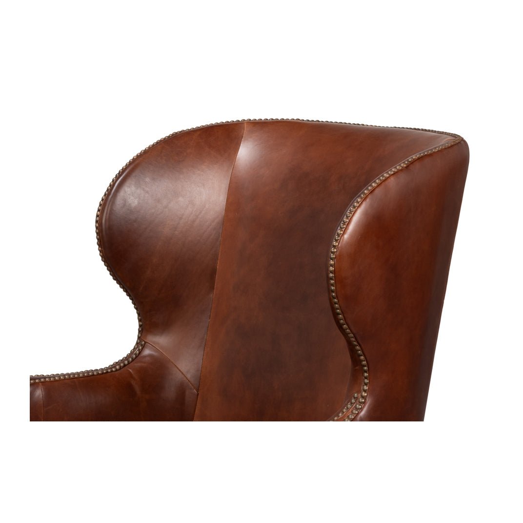 Side view of brown leather wing chair backrest.