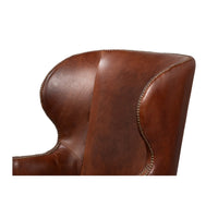 Side view of brown leather wing chair backrest.