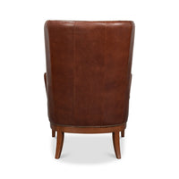 Brown leather wing chair back view.