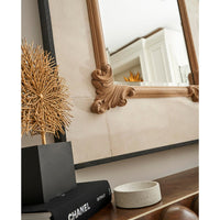 Mirror on wall, close-up with decor items.