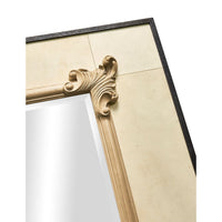 Corner of ornate wall mirror with scroll detailing.