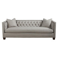 Beige tufted sofa with pillows, front view.