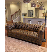 Chesterfield sofa in living room setting, cozy and stylish.