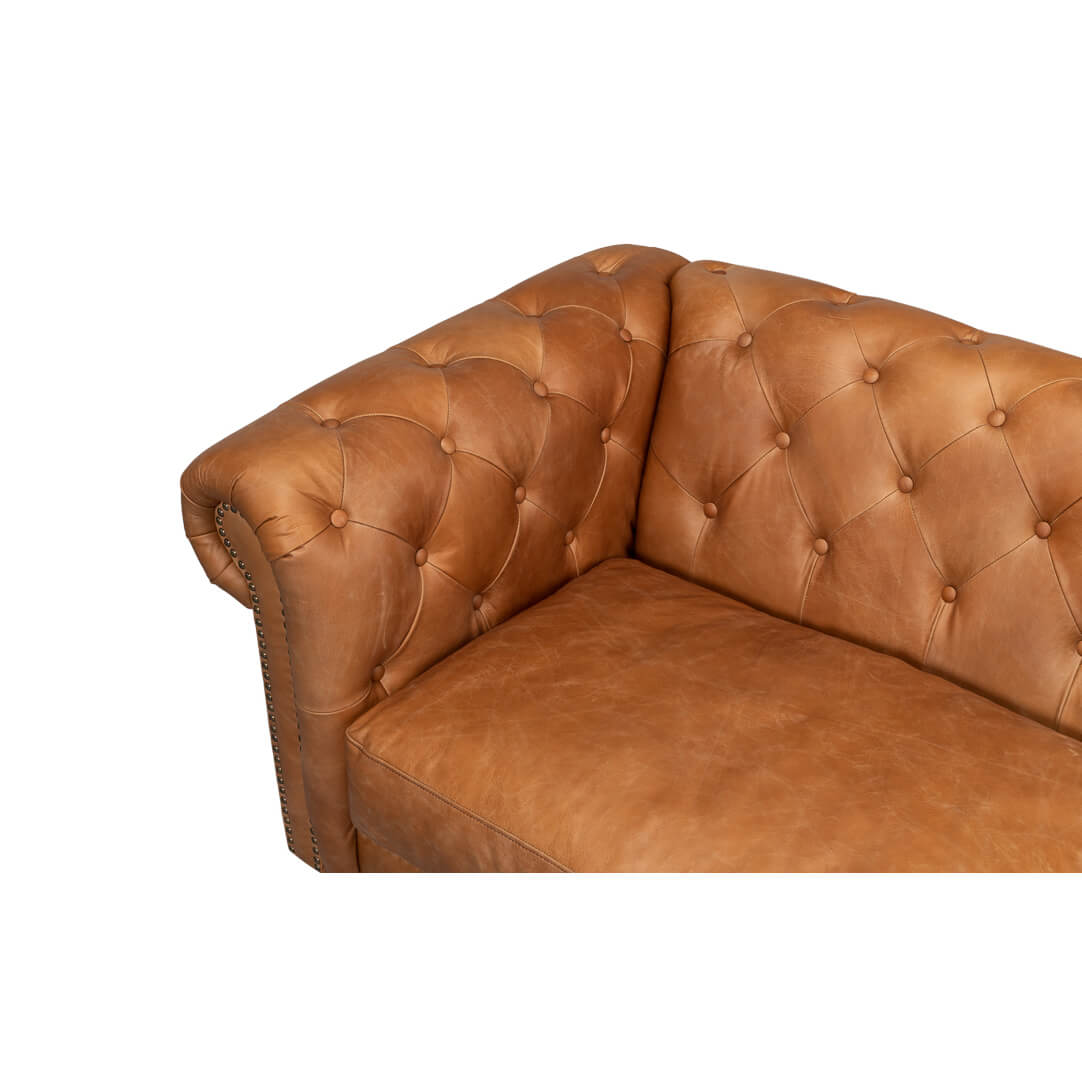 Close-up tufted armrest chesterfield sofa.