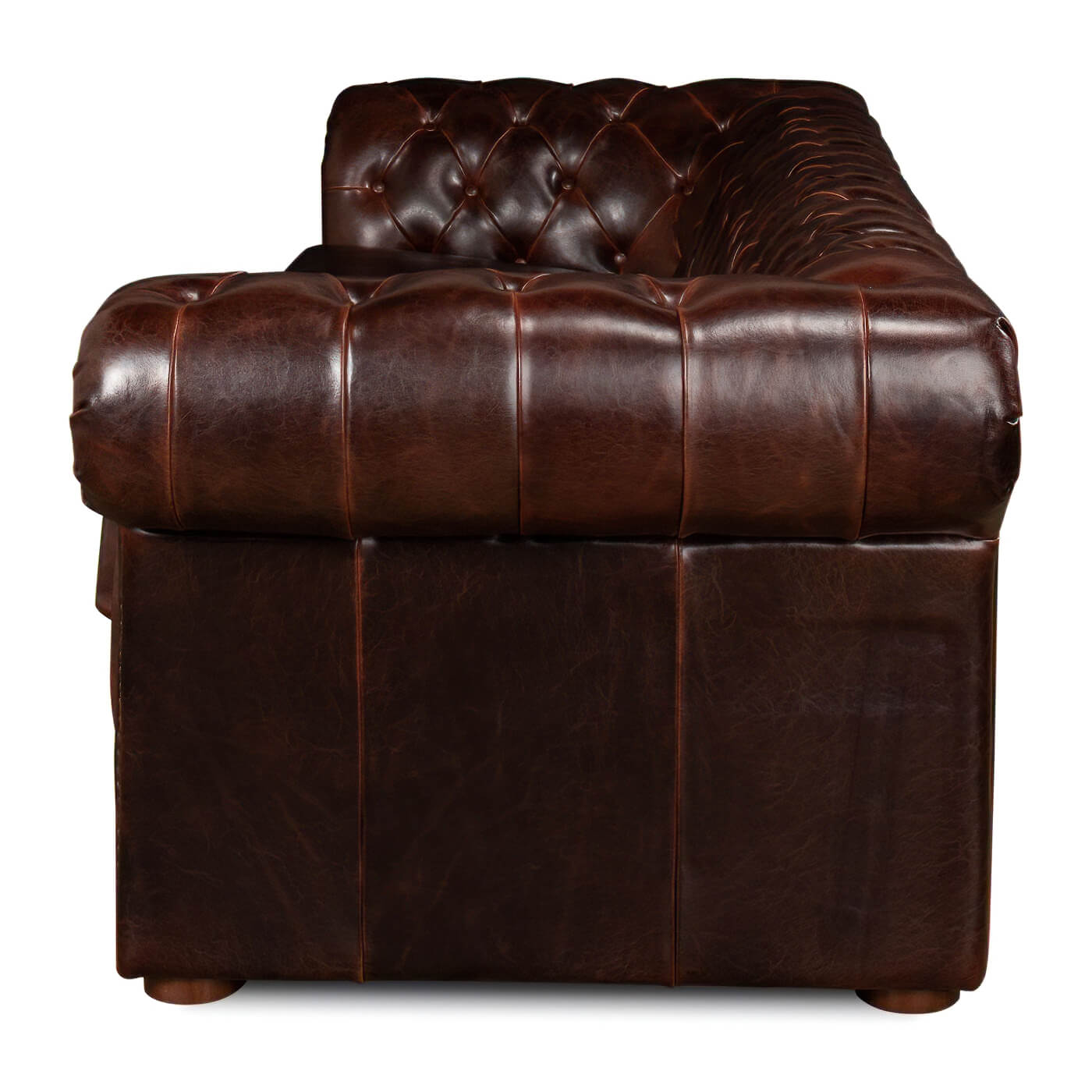Side view tufted leather Chesterfield sofa armrest detail.