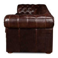 Side view tufted leather Chesterfield sofa armrest detail.