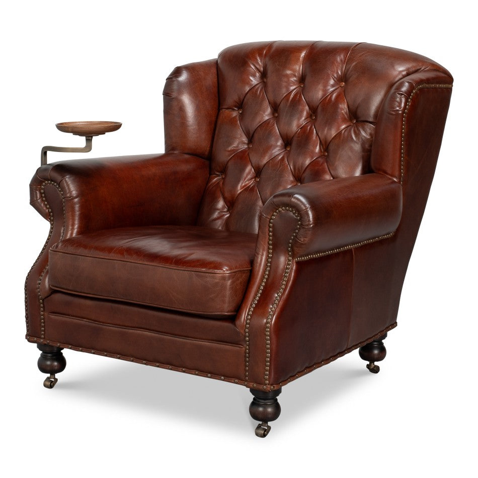Tufted brown leather club chair with swing-arm wood tray and nailhead trim