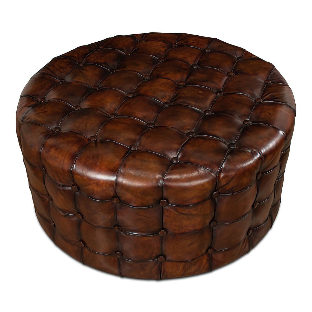 Brown leather round ottoman, tufted detailing, angled perspective.