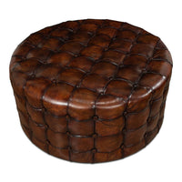 Brown leather round ottoman, tufted detailing, angled perspective.