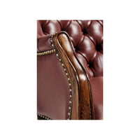 Wooden armrest with nailhead trim on chair.