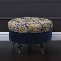 Elegant tufted ottoman with intricate pattern on dark surface.