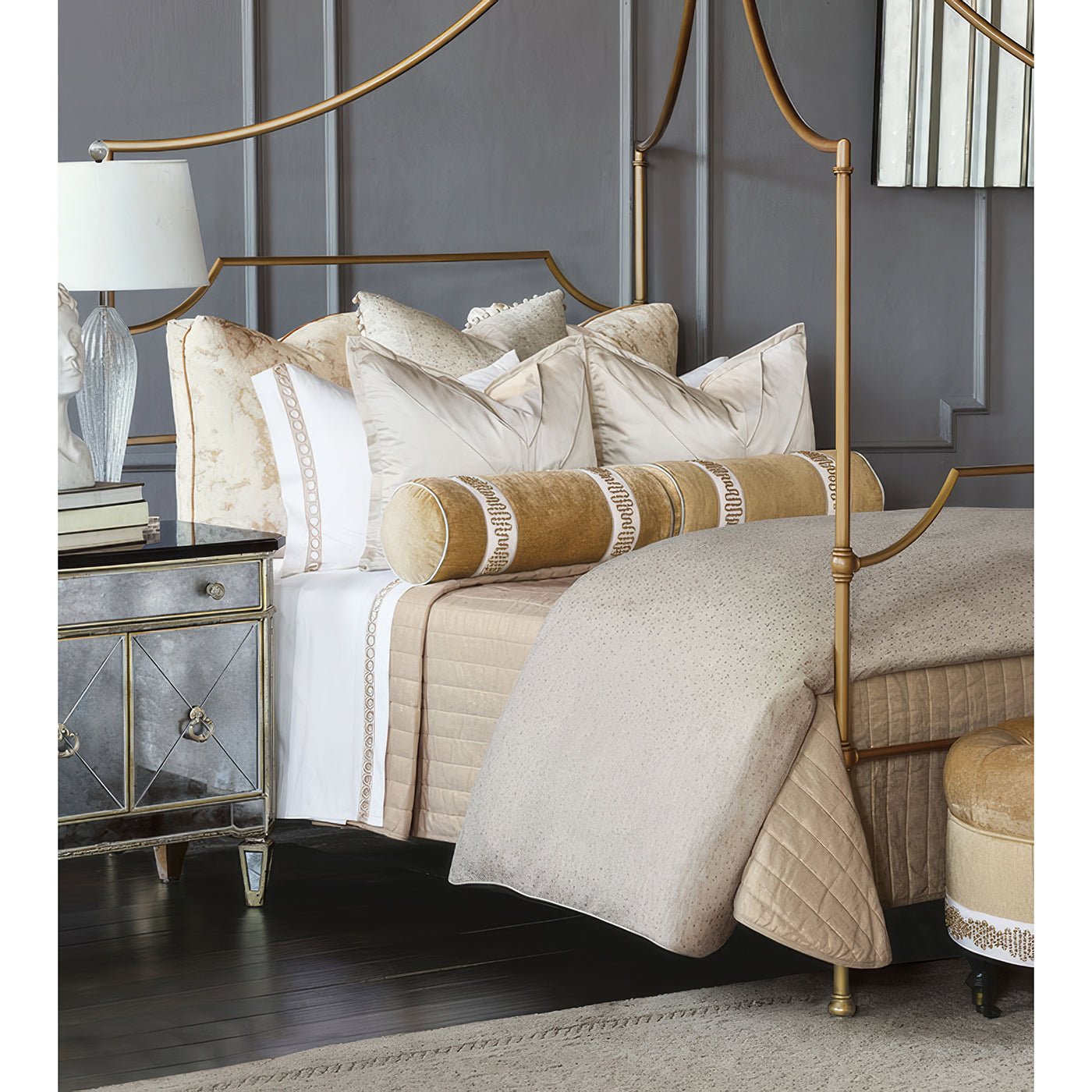 Bedroom with tufted ottoman and luxurious bedding set.