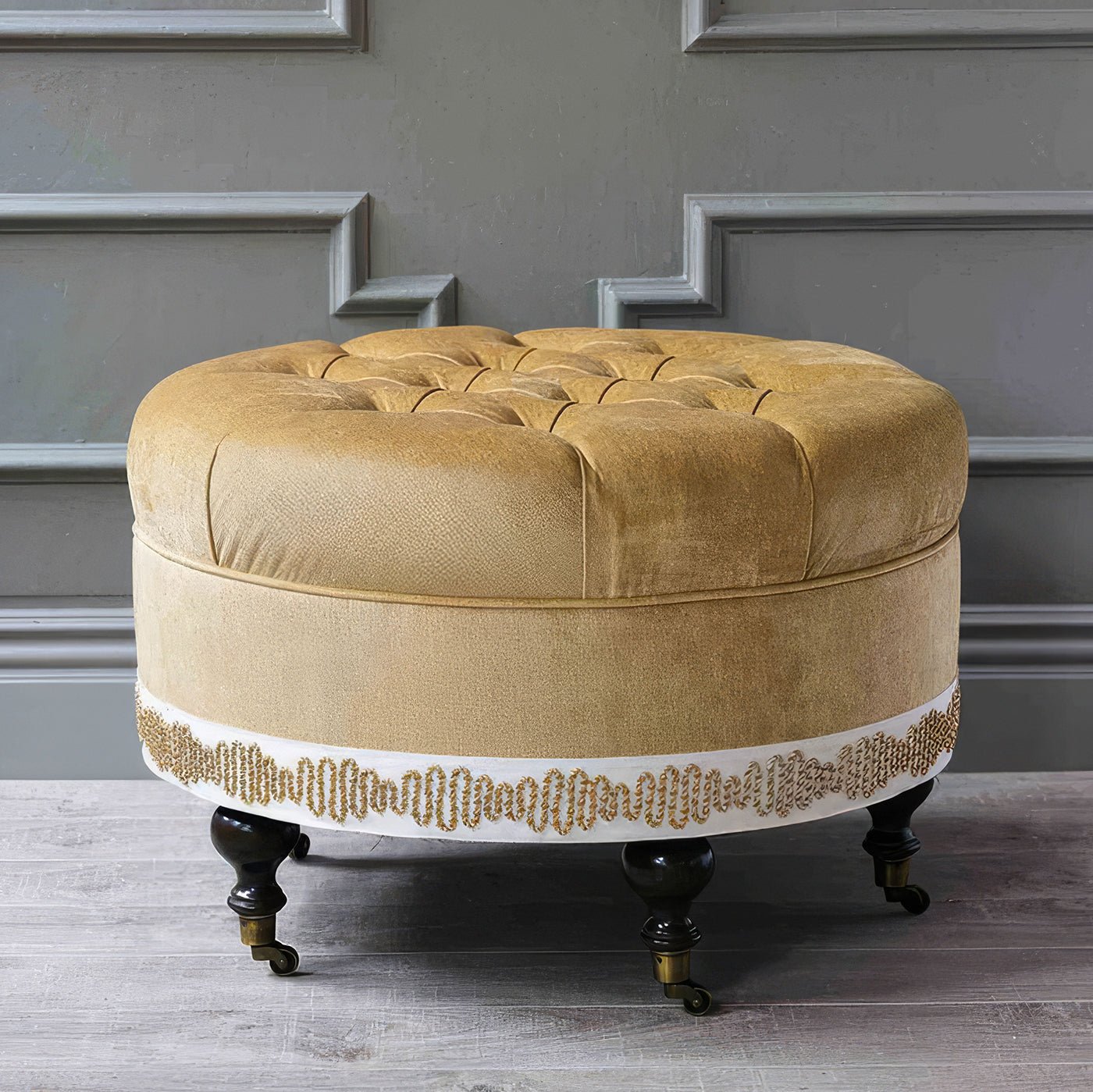 Velvet ottoman in elegant room with molding details.